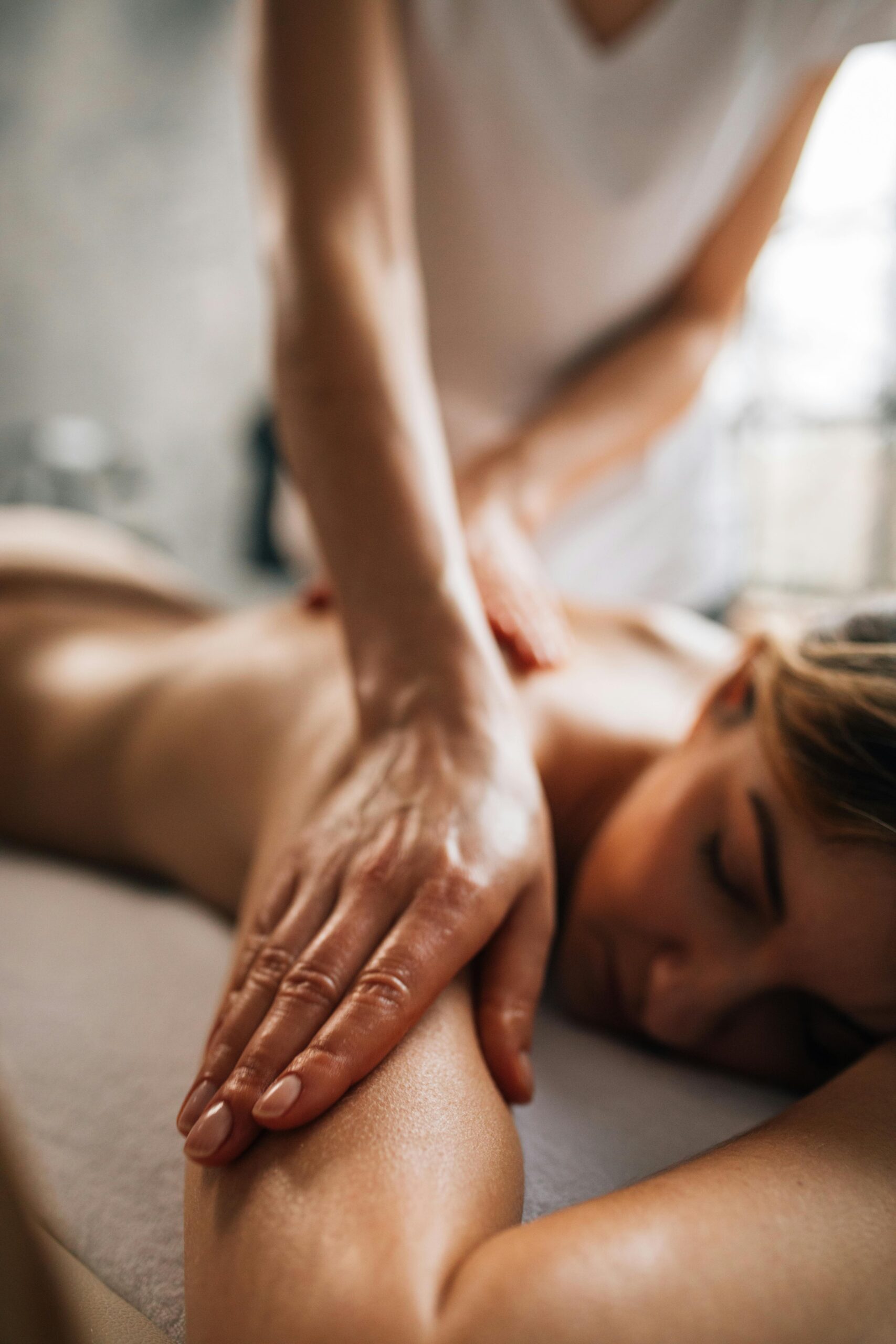 A woman enjoying a relaxing massage in a serene spa environment, promoting self-care and wellness.